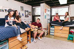 Student with guitar and other students