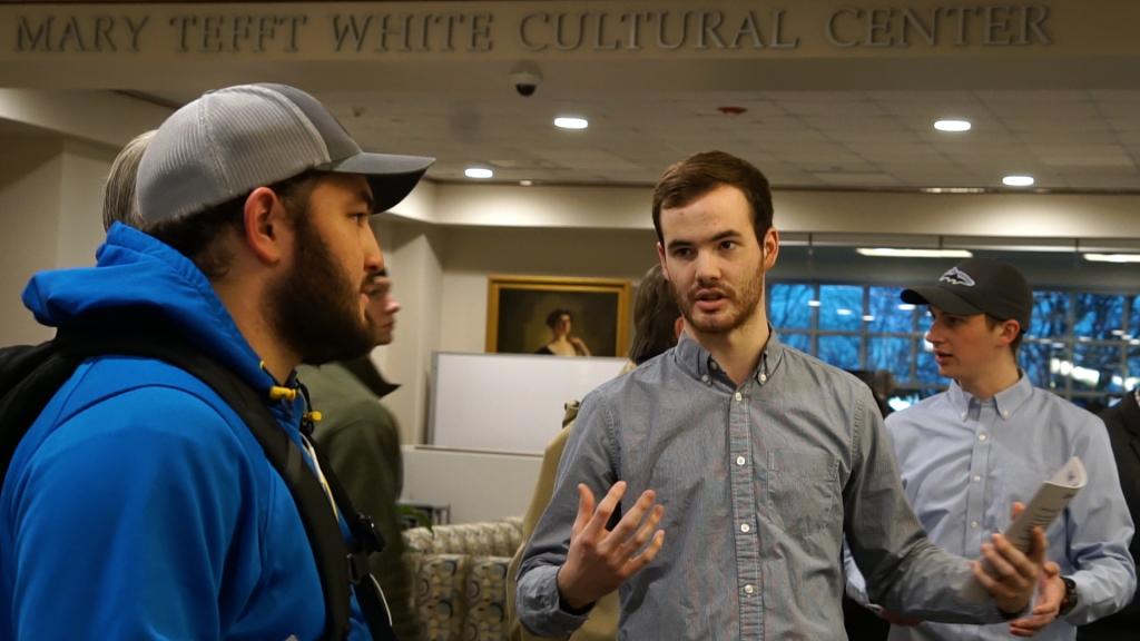 Students explain pieces in the library exhibit.