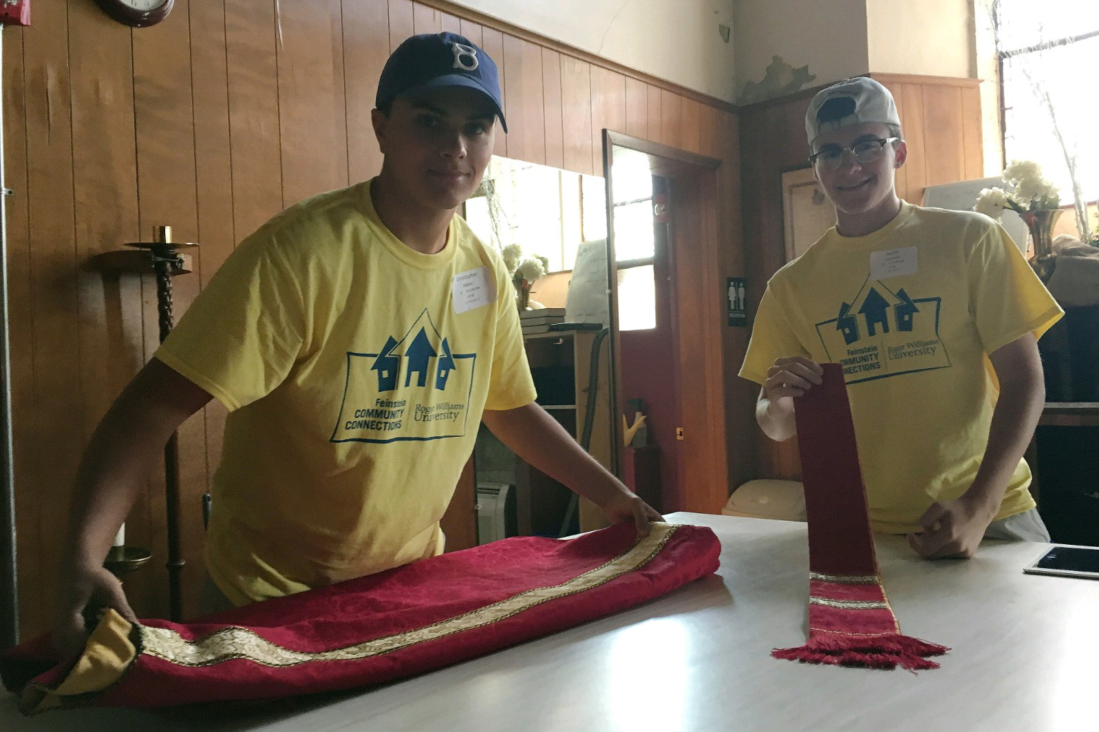 Students fold vestments inside church sanctuary