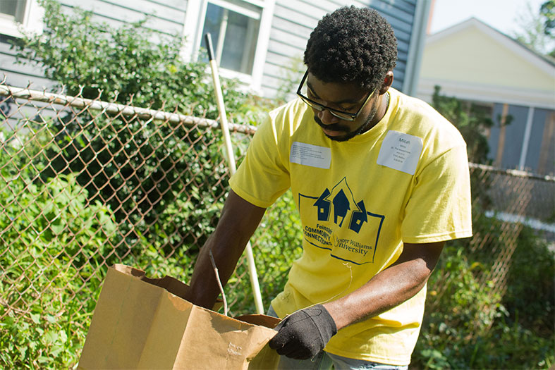 Student weeds a garden at a community center.