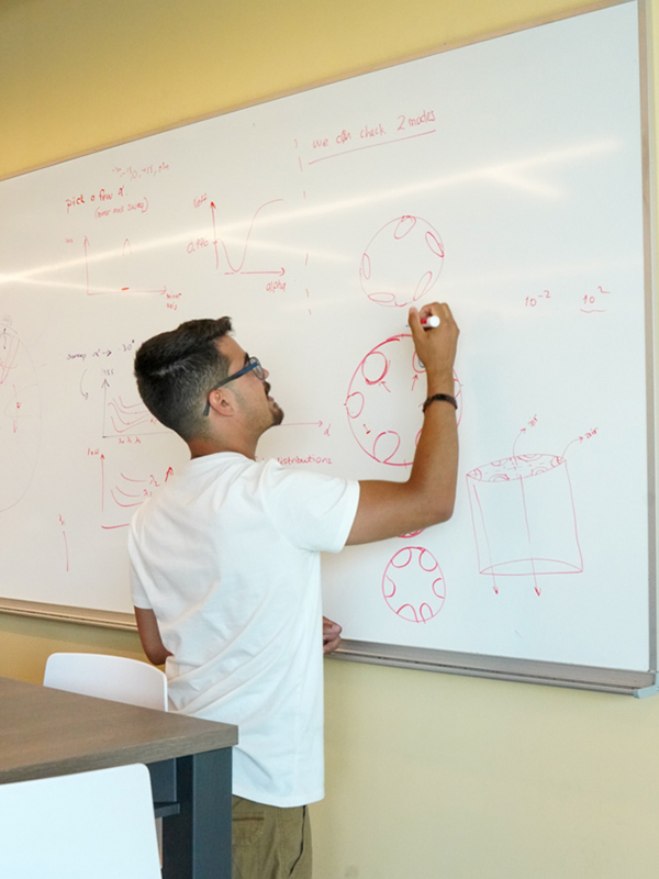 Senior Santiago Armas writes on a whiteboard. 