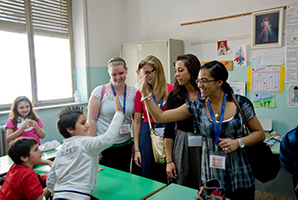 Students high five children.