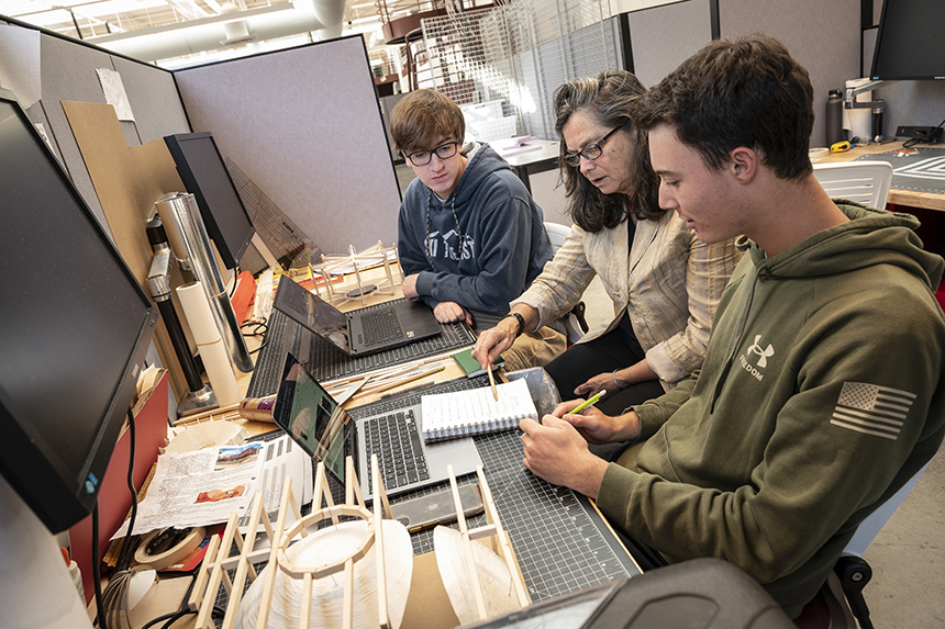 Two students and a professor working in the Arch building 