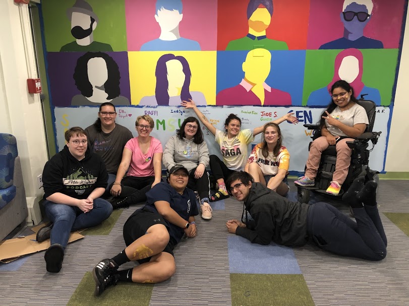 Group of students in front of painted mural in QTRAC