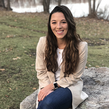 A photo of alumni Rebecca Millard sitting outside 