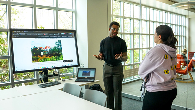 A student talks about his video game project during SASH 