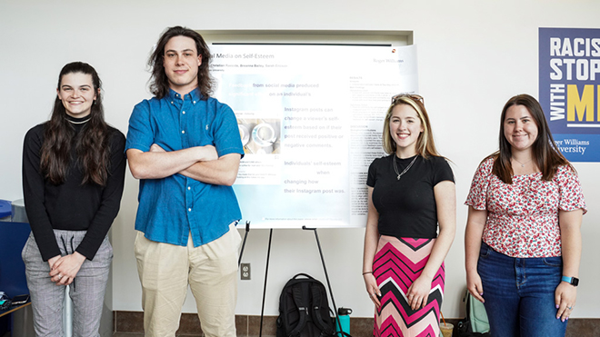 Four students standing with their SASH poster