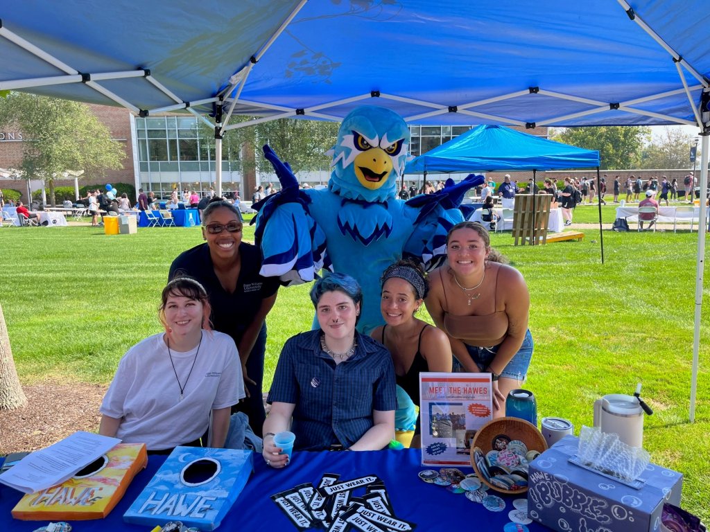 students smiling with Swoop the Hawk