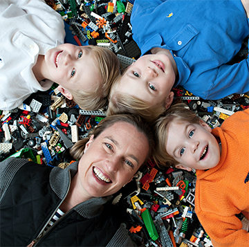 Amy Fazackerley and her three sons lay on a pile of legos 