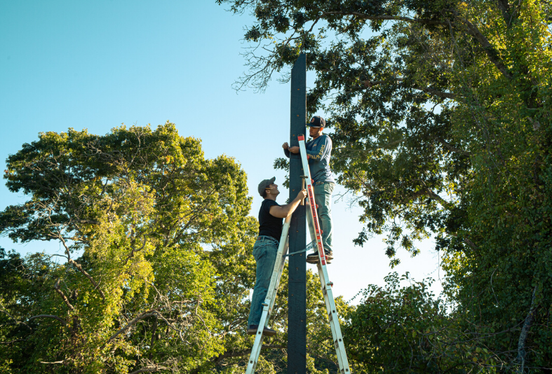 Students on ladders, putting up piers.