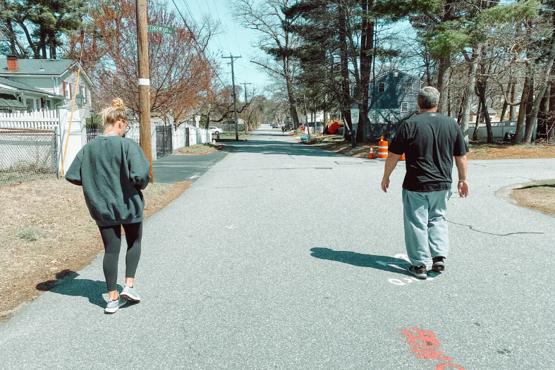 Two people walking in the road.