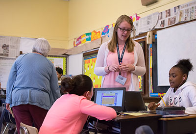 A student teacher works with students.