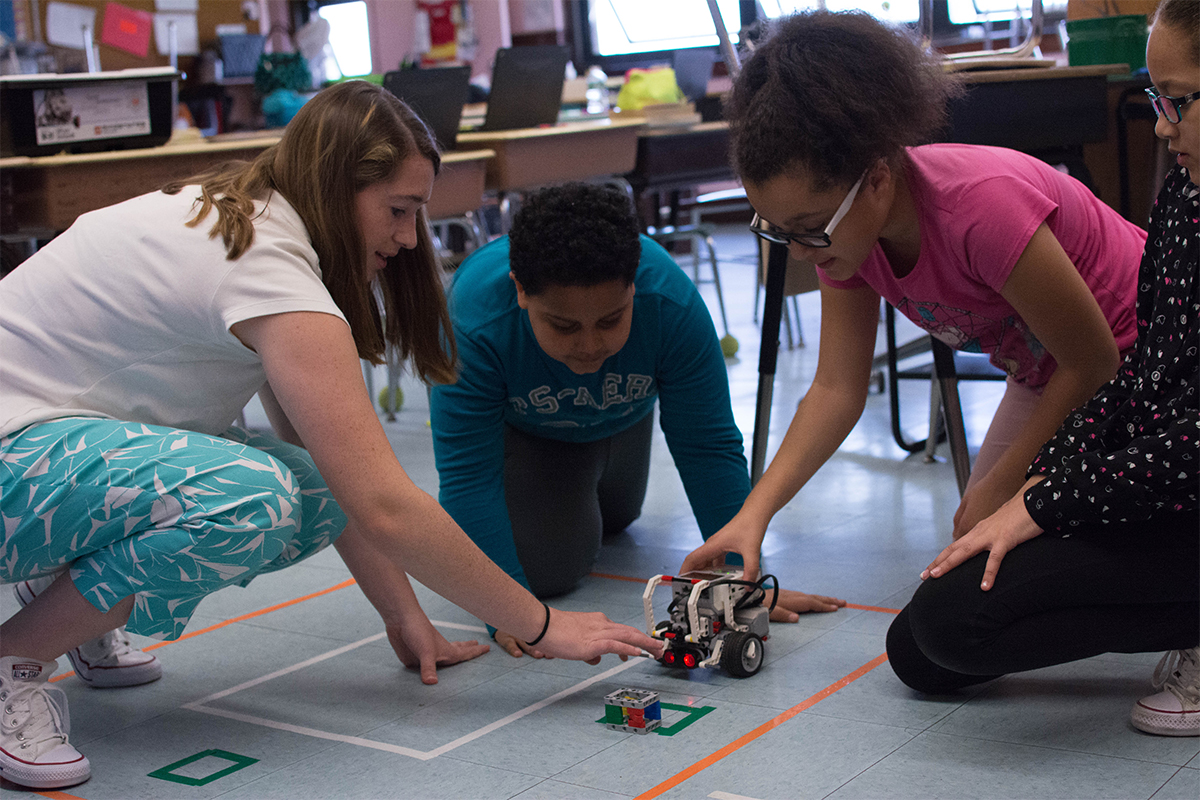 RWU student works with three elementary students