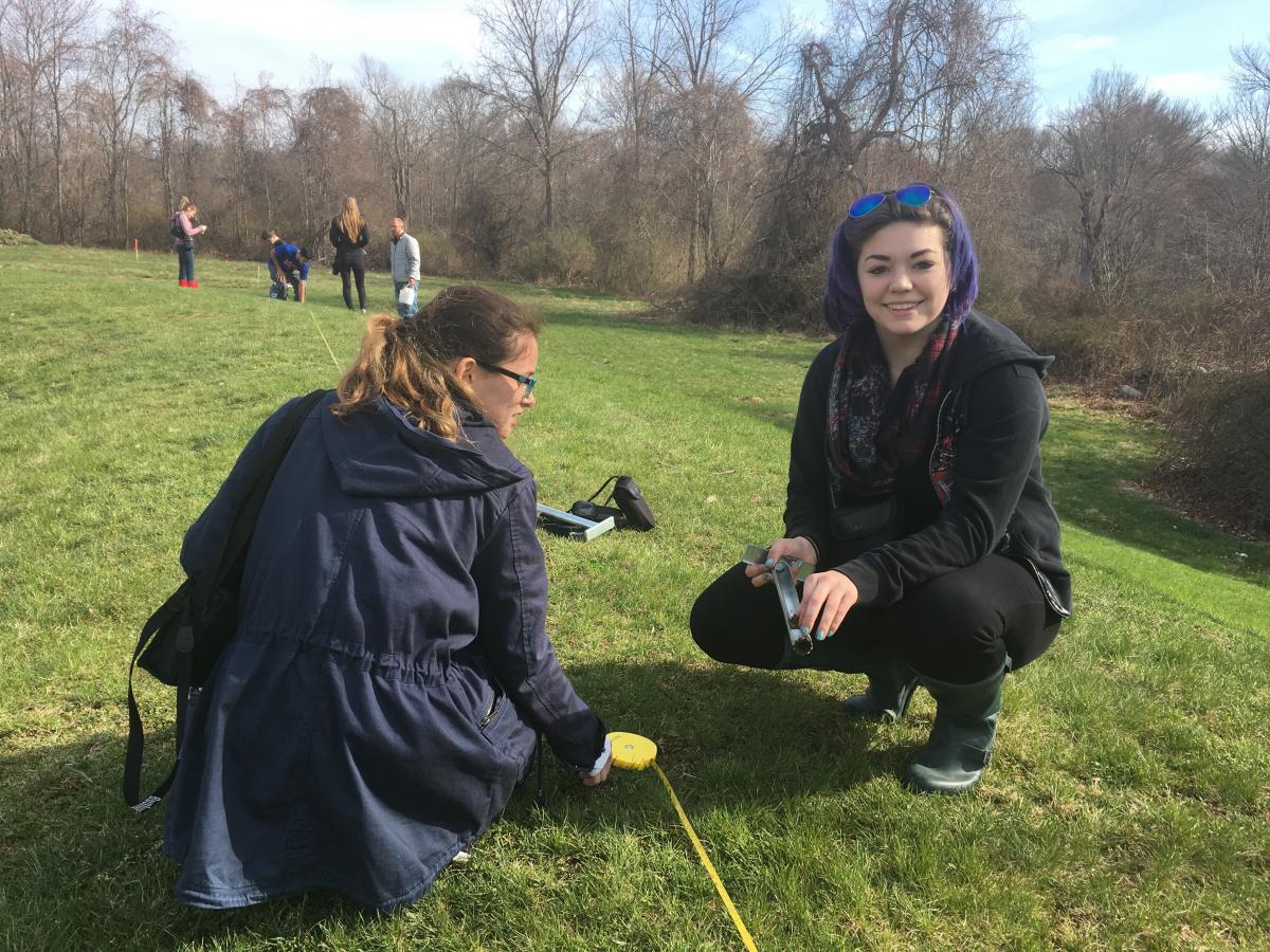 Students collect soil sample.