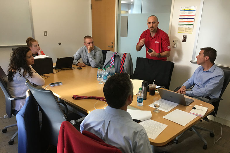 Students observe moderators prep for debate.