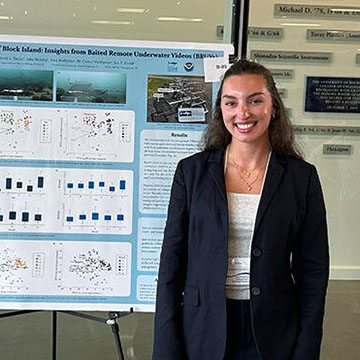 Talia Moine stands in front of her research poster