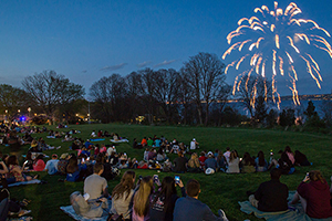 students sitting outside watching fireworks