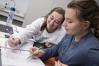 Two students sit together working