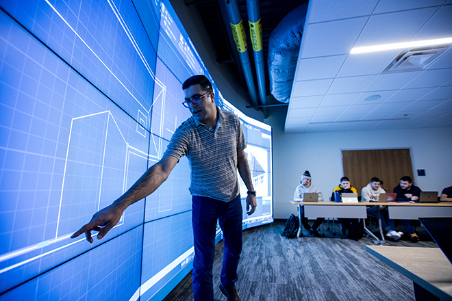 Professor pointing at content on video wall