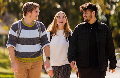 Students walk together and smile on campus