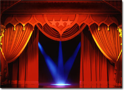Stage curtain revealing follow spots.