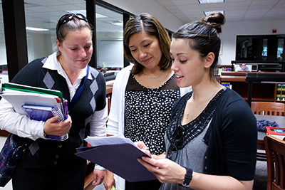 Three students look at notes