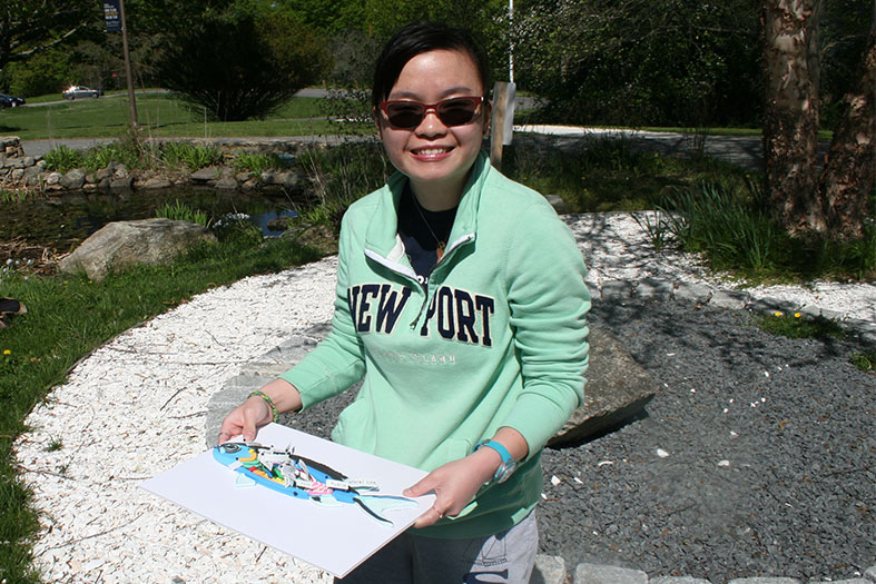 Student displays her sculpture of a fish dissection.