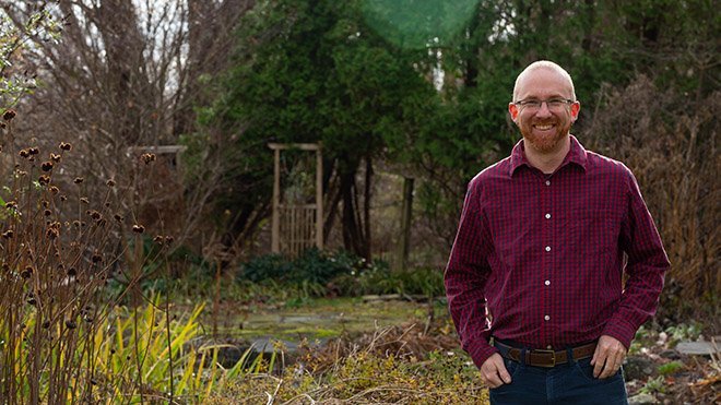 RWU Professor Loren Byrne stands in his backyard.