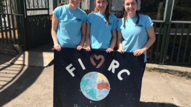 RWU Students hold FIMRC sign. 