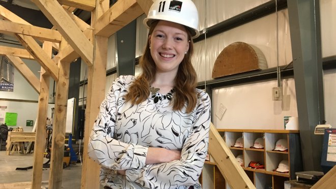 Graduate stands inside university fabrication facility