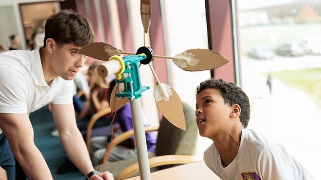 A Roger Williams University student teaches a local fourth-grade student about wind turbine design.