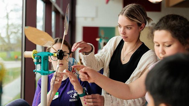 An RWU student helps fourth-grade students with a wind turbine project