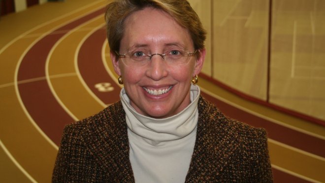 Athletic director stands on indoor track.