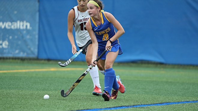 image of Lea Peterson looking to pass the ball in a field hockey match