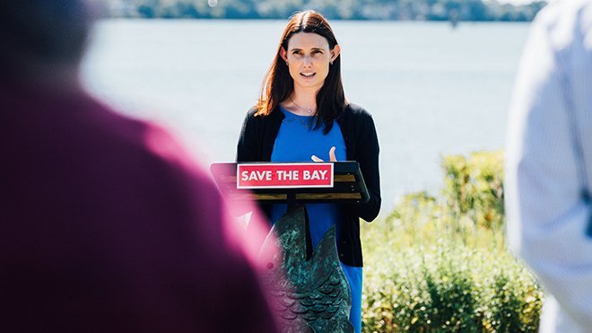 Lillian Jeznach speaking at a podium outside the Save The Bay headquarters in Providence