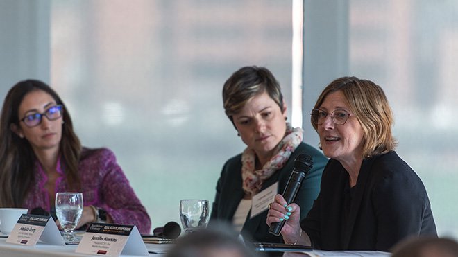 Three panelists sitting at a table at the Real Estate Symposium 