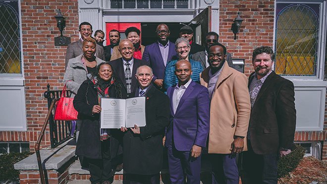 City and project leaders pose in front of church.