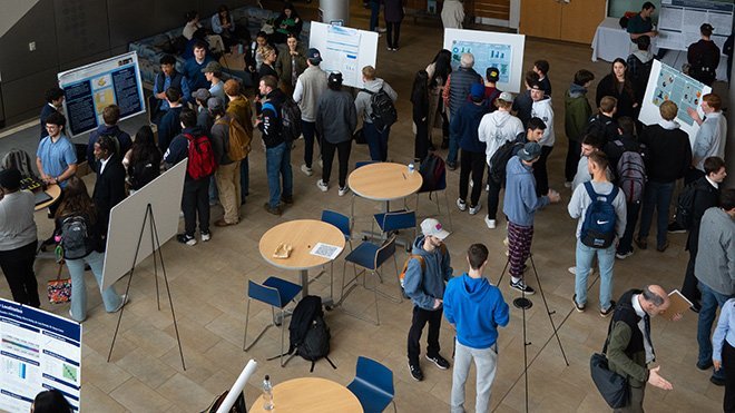 People in the GHH atrium looking at posters as part of SASH