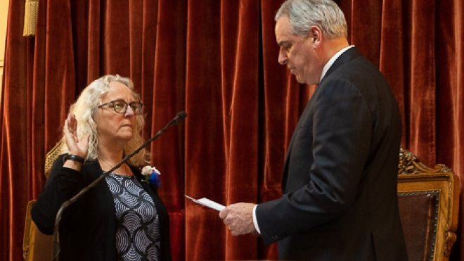 Speakman raises hand to swear in. 