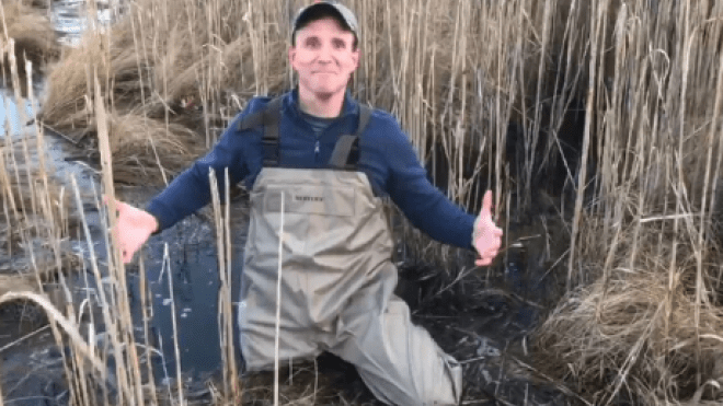 Person crouching in mud.
