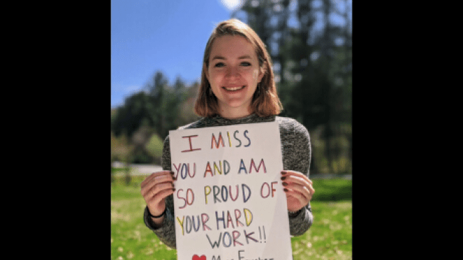 Student holding up sign. 