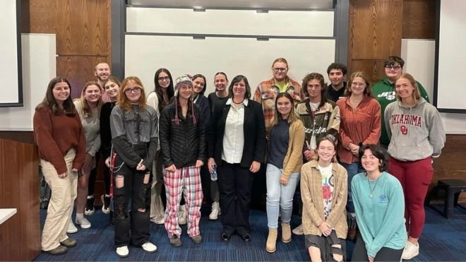 The Science Alliance club members gather smiling around guest speaker Claudia Turro in the center.