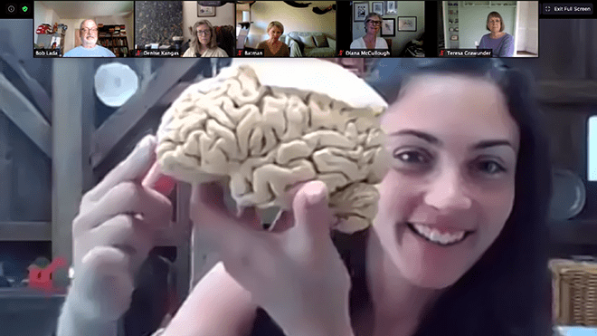 Victoria Heimer-McGinn holds up brain on Zoom screen 