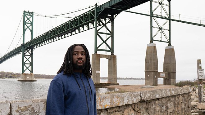 image of RWU senior Christian Thomas on Bristol Campus beneath the Mount Hope Bridge, a popular student hangout 