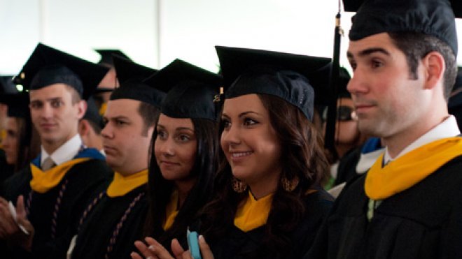 Students watch graduation ceremony.