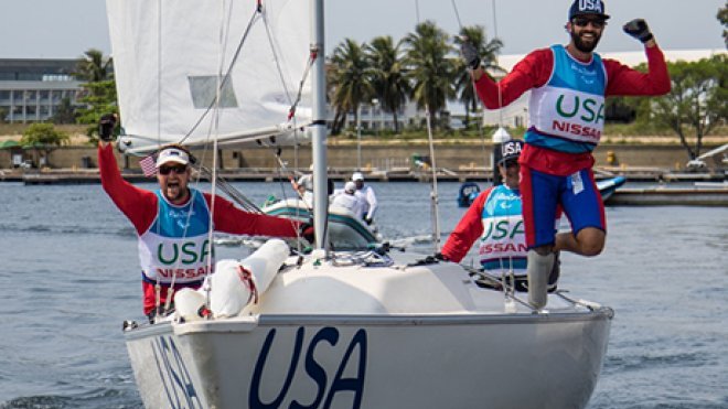 Parasailing athletes navigate their boat.