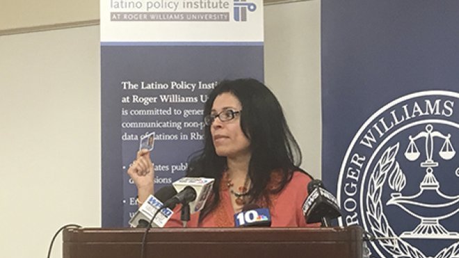 A woman addresses an audience at a press conference.