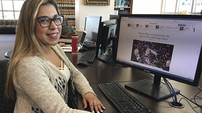 A student reads the New York Times website inside the library.