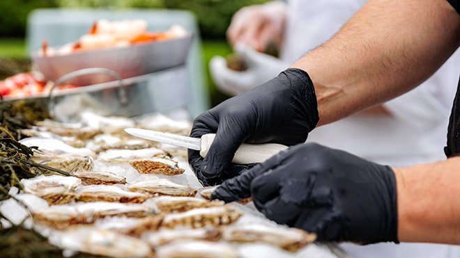 Shucking oysters for buffet.