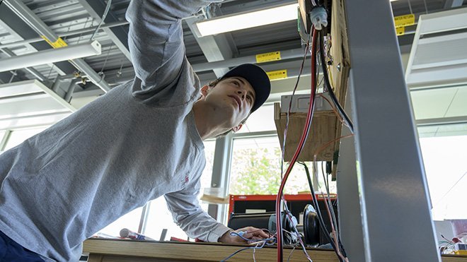 An Engineering student connecting wires in a lab